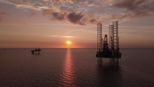 Aerial view of offshore jack up drilling rigs during beautiful sunset. Oil and gas industry