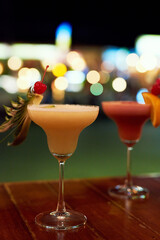 Table, beverage or cocktails in nightclub for party with happy hour and weekend entertainment. Margarita or mojito, fruit and drink in restaurant with alcohol glasses for celebration in Costa Rica