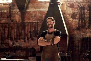 Young man, blacksmith and metal with confidence in workshop for steel, welding or crafting. Male person, welder or crafter with smile, arms crossed or profession for manufacturing at factory or forge