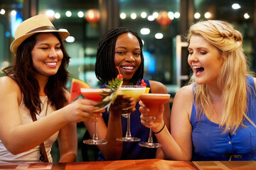 Cheers, cocktail and friends in nightclub with alcohol beverage for fruit drink, tropical pina colada or happy hour. Toast, diversity and women with glass for party, clubbing or nightlife