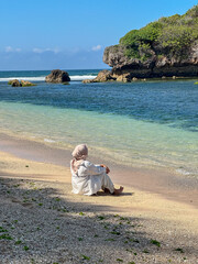 Indonesian young woman in hijab enjoying holiday on the beach