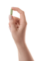Woman holding vitamin capsule on white background, closeup. Health supplement