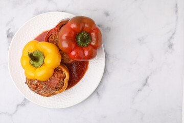 Delicious stuffed bell peppers served on white marble table, top view. Space for text