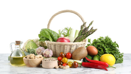 Healthy food. Basket with different fresh products on marble table against white background