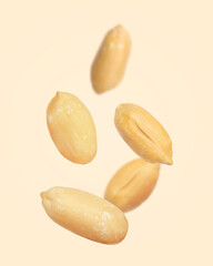 Many peanuts in air on beige background