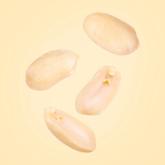 Many peanuts in air on beige background
