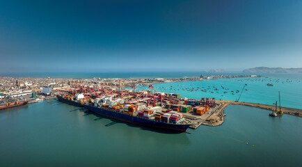 Aerial view of the port of Callao in Lima, Peru, showing port activity with containers and cranes in full operation. In the background can be seen the city and the Pacific Ocean