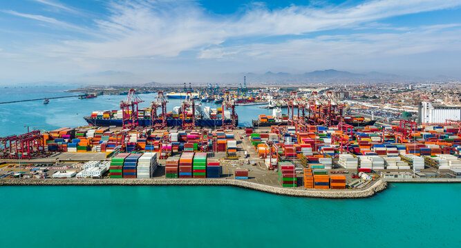 Aerial view of the port of Callao in Lima, Peru, showing port activity with containers and cranes in full operation. In the background can be seen the city and the Pacific Ocean