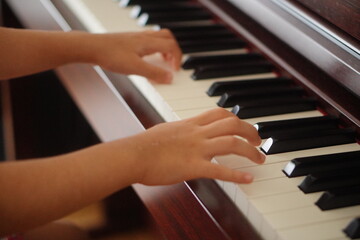 子どもが電子ピアノを弾いている手元。小学3年生。
