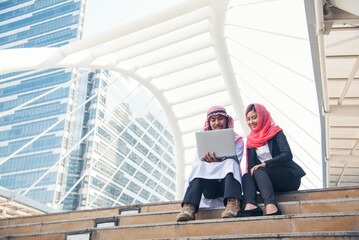 Fototapeta premium Arab team hold digital tablet uae union teamwork people. Digital marketing arab group of people using smart tablet discuss modern muslim UAE city. Entrepreneur Asian people smile teams meeting.