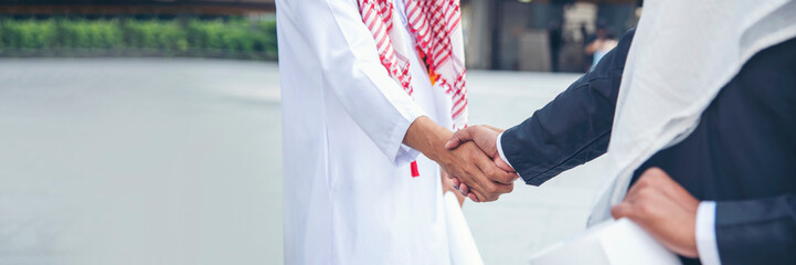 Banner Arab Businessman shaking hands together. Teamwork business partner wear Muslim dress Shake...
