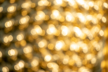 Fototapeta premium Gold texture design element blurred background glittering. Golden pattern backdrop decoration with copy space. Magic yellow orange shiny glowing selective focus. Glamour effect gold antique defocused