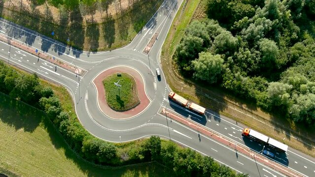 Aerial view of vehicles taking a two-lane roundabout in the countryside.