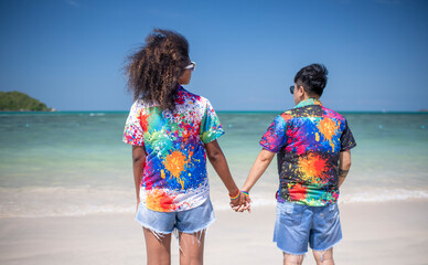 LGBTQ couple lover holding hand pose happiness life on beach in summer holidays vacation is...
