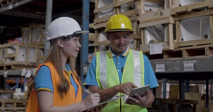 Warehouse management team use bar code scaner scan goods shelf writing checklist on clipboard. Asian men women worker check stock inventory. Teamwork logistics staff counting products store inventory