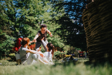 Young adults in casual wear play joyfully in a sunlit park, epitomizing friendship and happiness in...