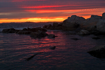 Naklejka premium Colourful Sunset Over Rocky Silhouette Ocean