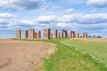 green cornfields, cloudy skies, ruins of red bricks and rubble