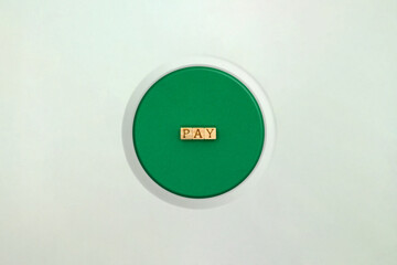 PAYの英語ブロックが中心にある丸い緑色の立体的な押しボタン