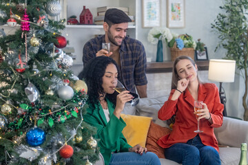 Diverse startup colleagues enjoy drinks, socializing in a relaxed, stylish living room post party.