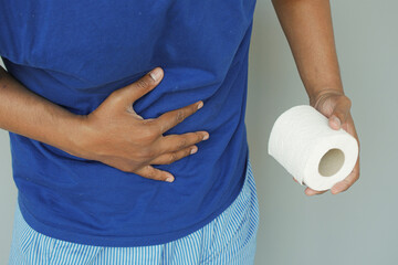 Man with stomachache holding toilet paper.