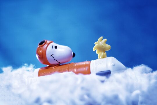 photo of toy snoopy flying through the clouds