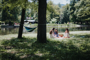 Three sisters painting together while sitting on a blanket in a park, surrounded by lush greenery...
