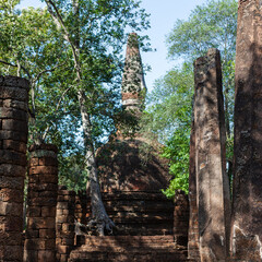 Old Buddhist stupa amidst lush greenery at Si Satchanalai Historical Park, Thailand.