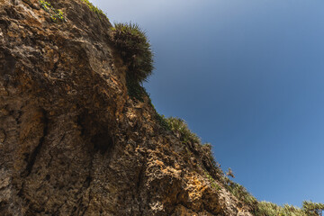 rocks on the beach ; beautiful nature with clear blue sky ; rocky indonesian beach archipelago