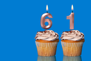 Birthday Cupcakes With Candles Lit Forming The Number 61.