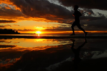 夕暮れの逗子海岸、ランニングする若者のシルエット