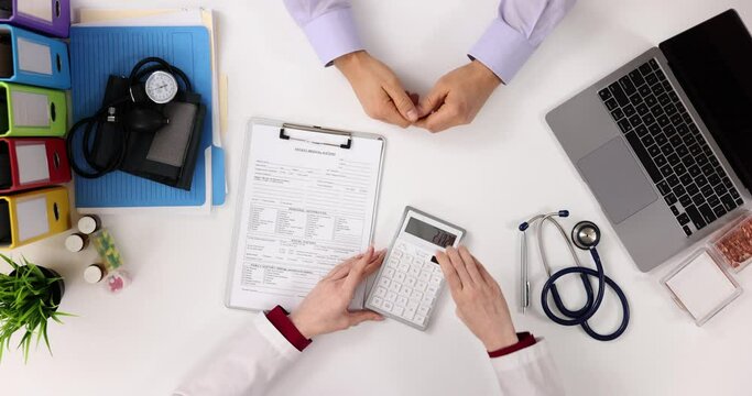 Doctor and patient discuss medical bill and payment for treatment top view