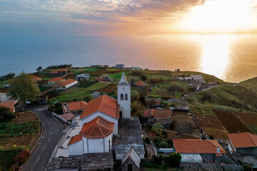 Hillside Village with Scenic Church during sunset with colorful sky over Madeira Island, Portugal.