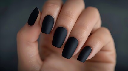 Hand with matte black manicure. Close-up studio photography. Beauty and personal care concept for design and print.