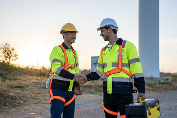 Technicians man making handshake while work in the wind turbines field.