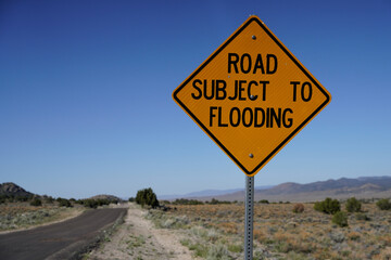 Road Subject to Flooding sign in desert.  Blue sky.