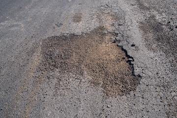Large pothole in remote desert road.