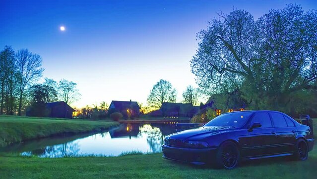 A BMW M5 - E39 Car Model Parked Near The Lakeshore At Sunset. Timelapse
