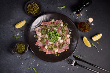 tuna carpaccio - slices of fresh raw tuna fillet on black ceramic plate