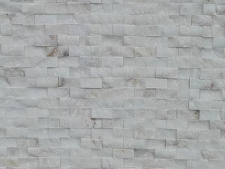 White marble brick wall grunge rustic. Marble wall for decorate a house. Marble wall patterned texture background. Gray marble wall as background for design pattern artwork.