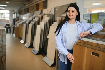 woman choosing laminate floor design from samples in flooring store