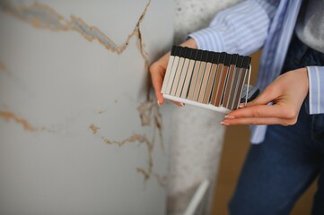 Female customer choosing kitchen ceramic tile in store