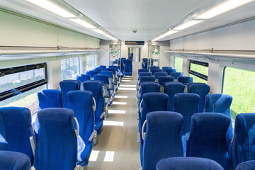 Short- and long-distance passenger train with blue seats without people. Selected focus.