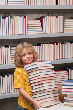 Back to school. School kid pupil studying in school library. Child reading book in library on bookshelf background.