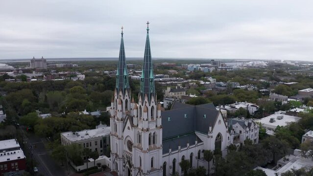 Aerial close-up push-in shot of the gothic spires atop the Cathedral Basilica of Saint John the Baptist in Savannah, Georgia. 4K