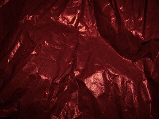 Wrinkled paper texture in dark red tones for a mysterious background.      