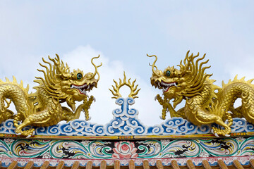 Chainese gold dragon on blue sky backgrounds. Traditional Chinese style rooftop
