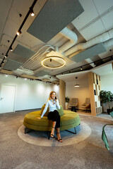 Businesswoman talking on phone in modern office lounge during the afternoon