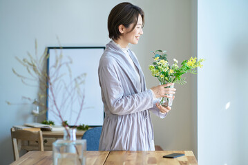 花を飾った花瓶を持つ女性