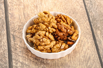 Cracked unshelled walnut in the bowl